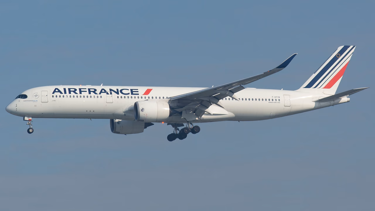 Air France Airbus A350 on approach with its landing gear down against a hazy blue sky