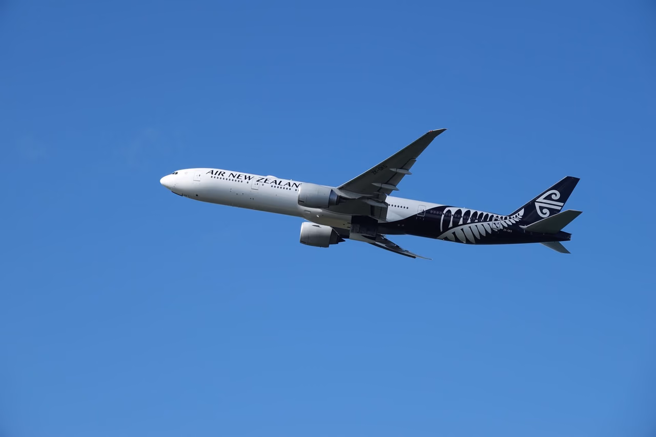 An Air New Zealand jet in flight against a clear blue sky