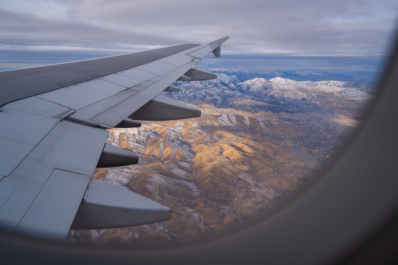 Snow-covered mountain ridges seen from an airplane window on a clear day