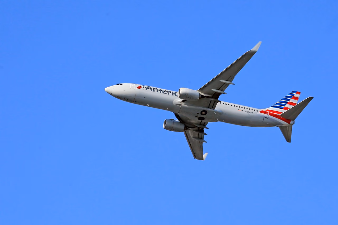 An American Airlines Boeing 737 in flight against a clear blue sky