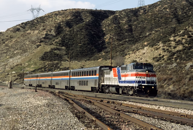 An Amtrak train traveling through hills in California