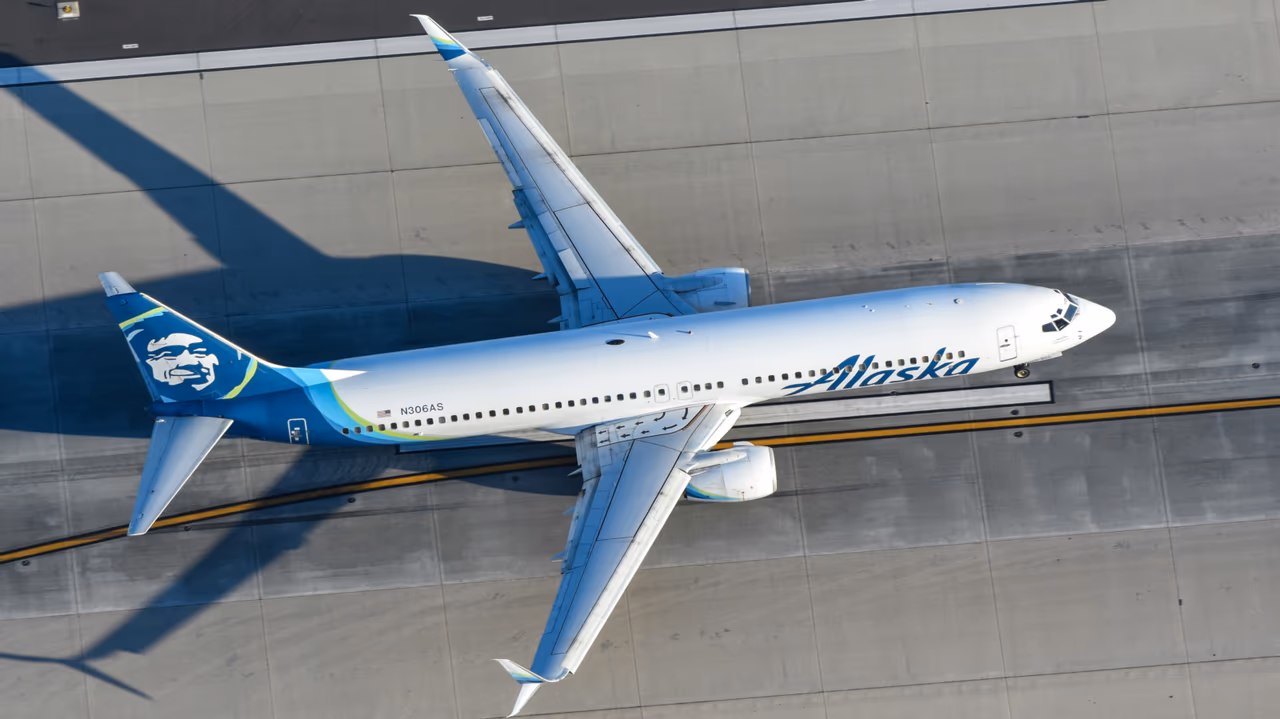 Alaska Airlines airplane taxiing on the runway viewed from above