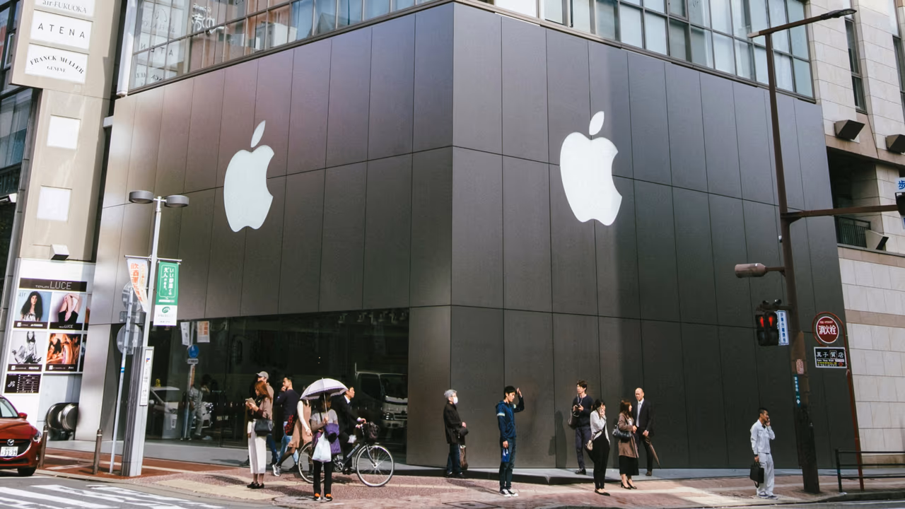 Apple Store exterior with large Apple logos and pedestrians outside.
