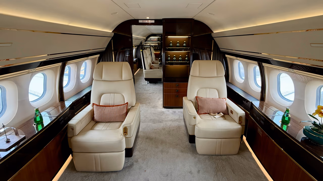 Luxury private jet interior with cream leather seats and wood paneling