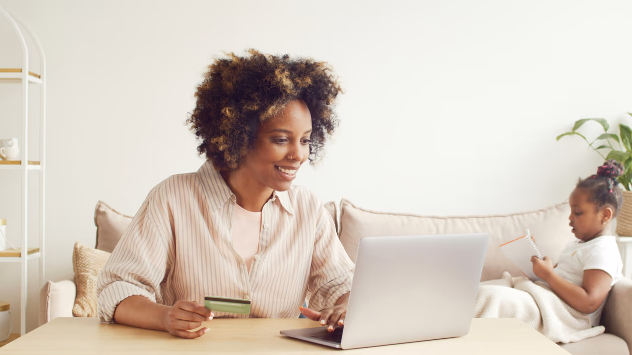 Woman online shopping with a credit card at home