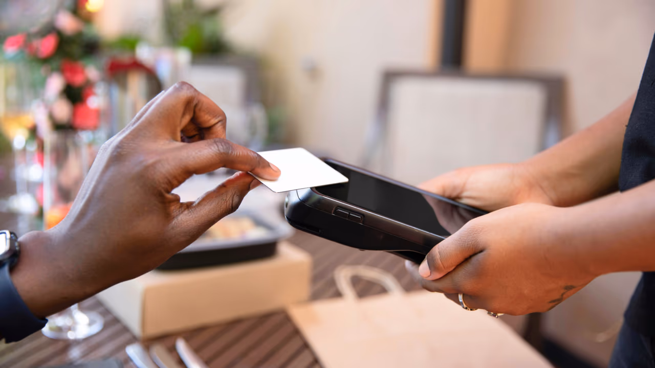 woman tapping her credit card to pay at a store