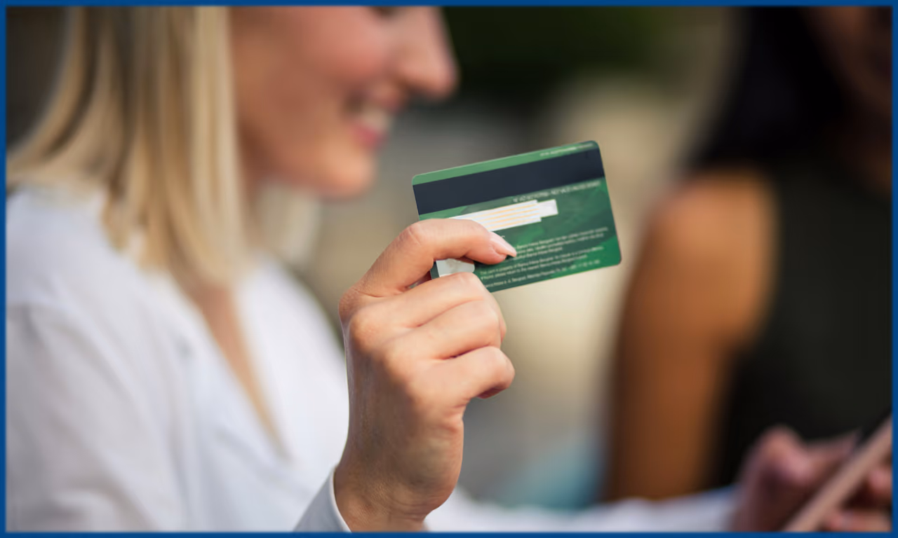 girl holding a credit card and an iphone