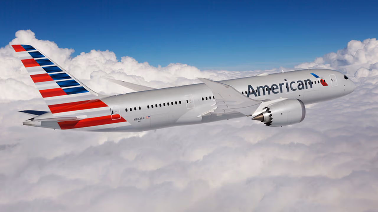 american airlines plane flying in the cloudes