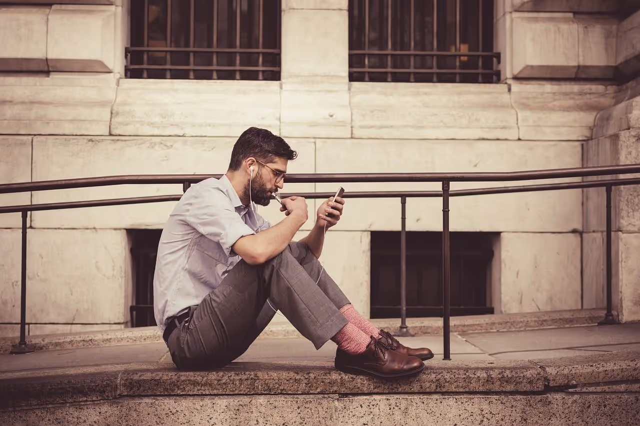 person sitting on a bench looking at their phone
