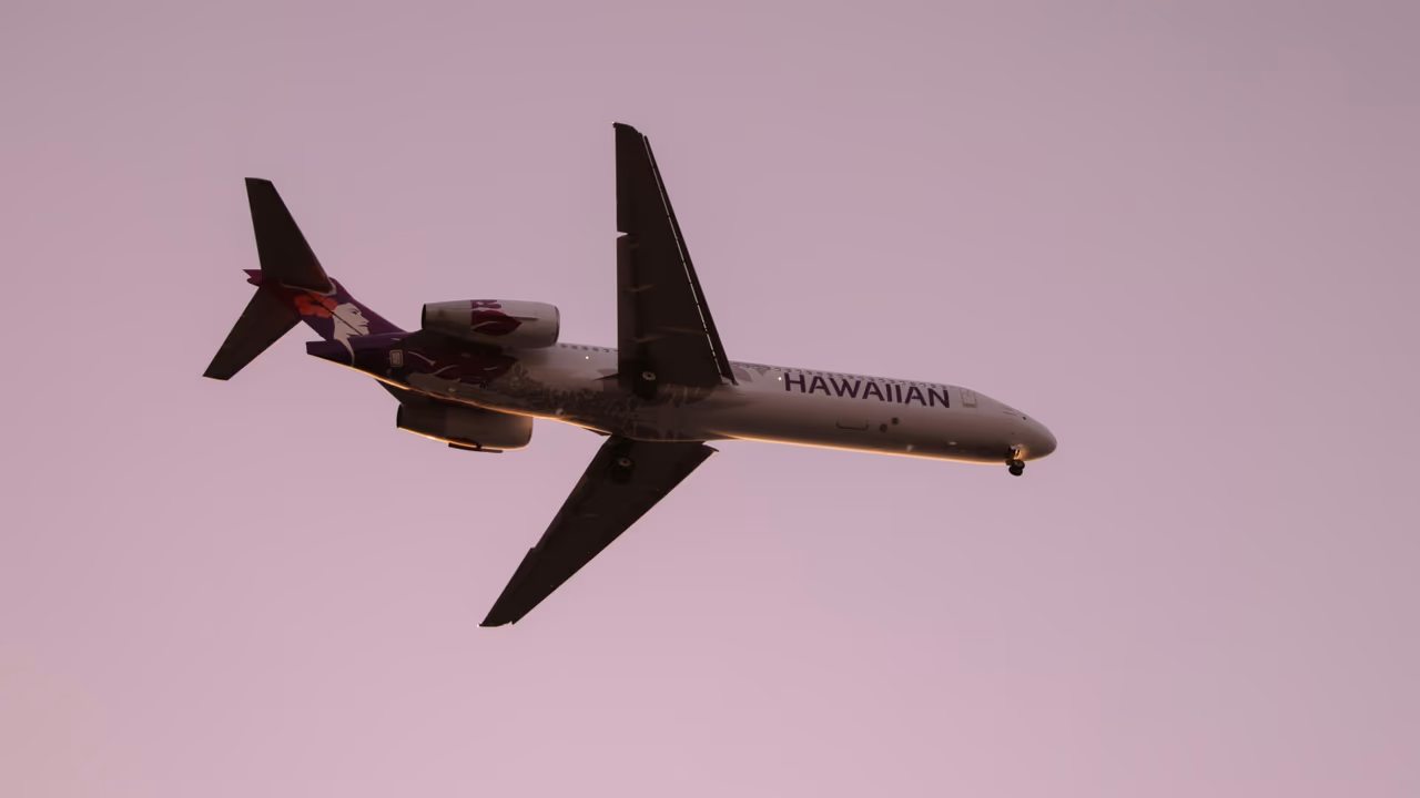 Hawaiian Airlines plane in sunset sky