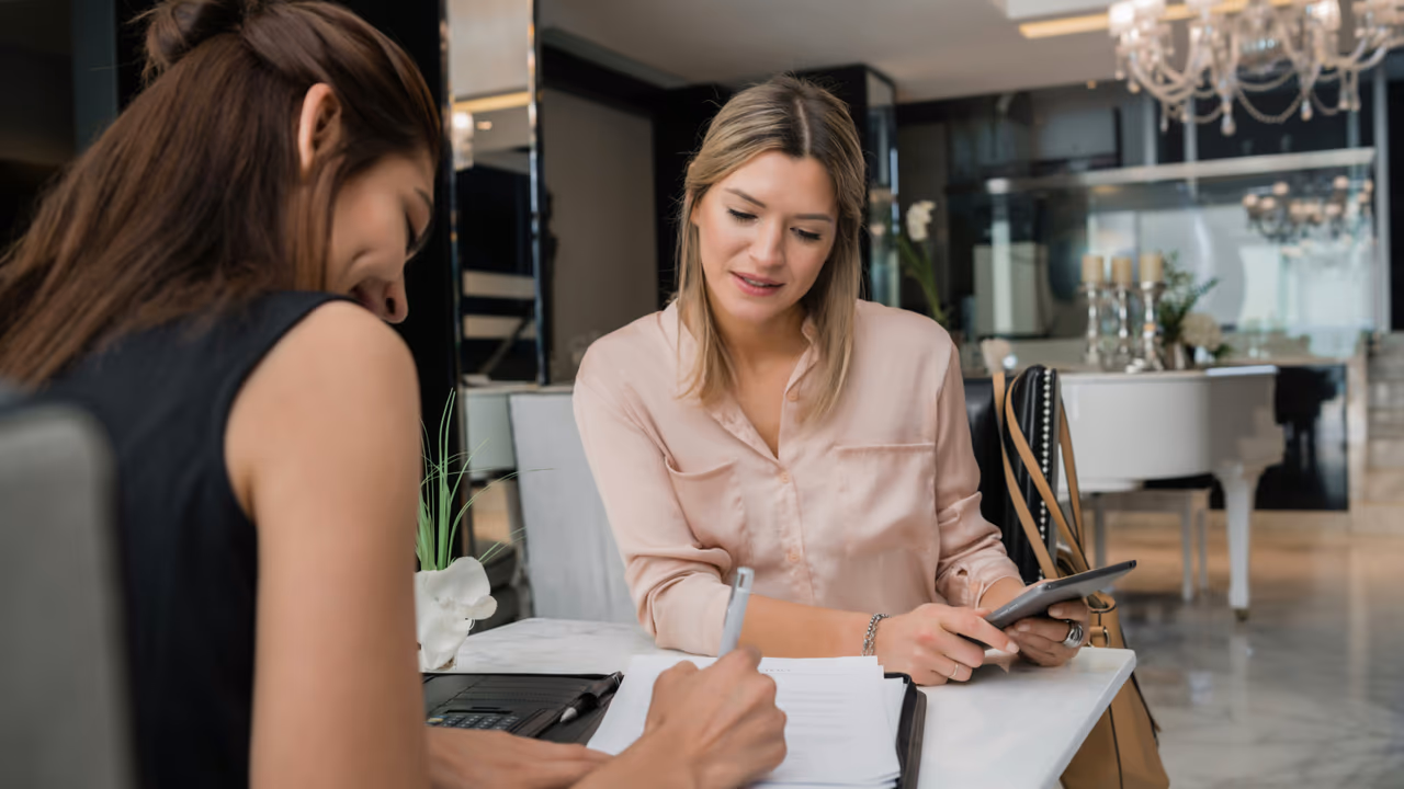 Two women booking hotels on laptop