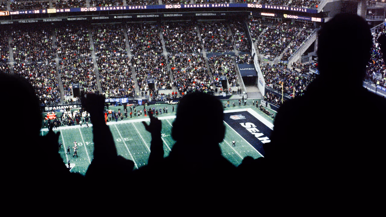 Football fans cheering inside a packed stadium