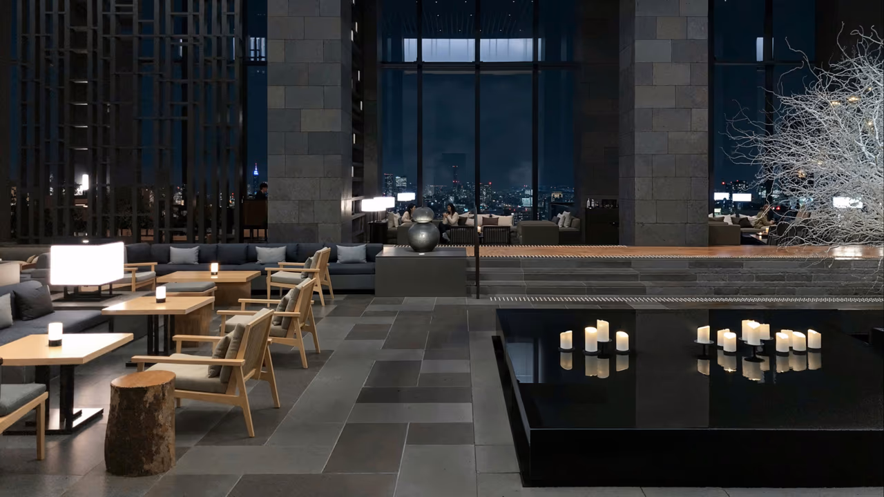 Modern hotel lobby with city skyline views at night