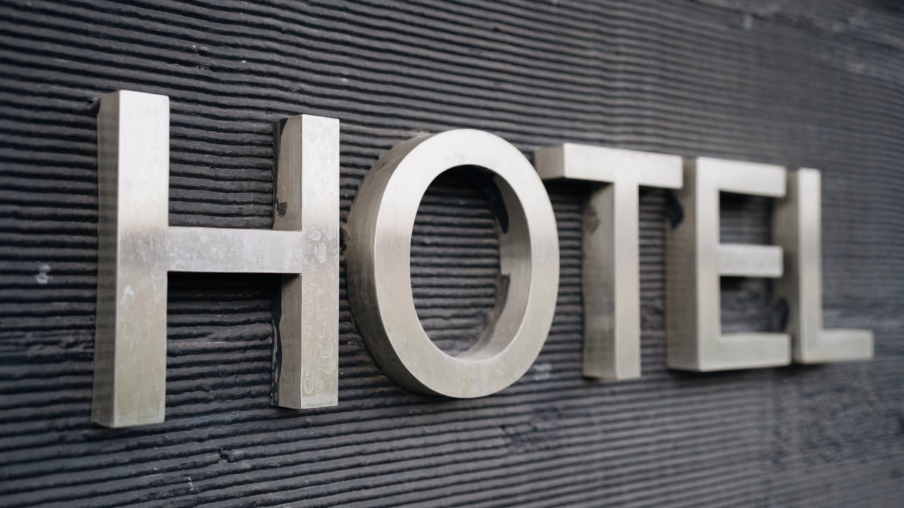 Metal hotel sign on dark wall