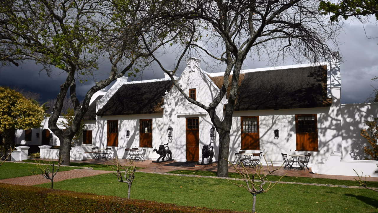 White historic house with trees and garden