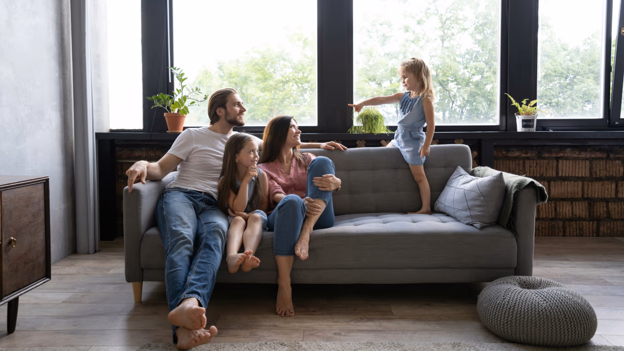 Happy family relaxing together on a living room sofa.
