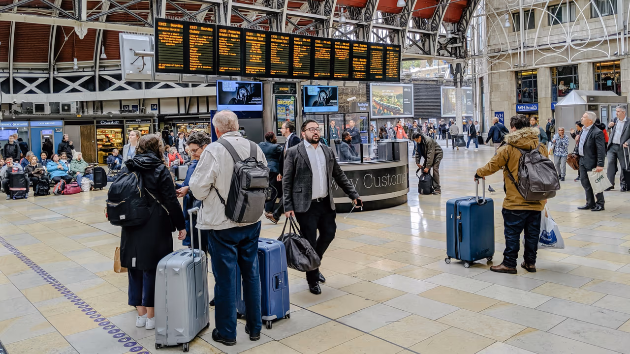 Travelers waiting at airport terminal with luggage