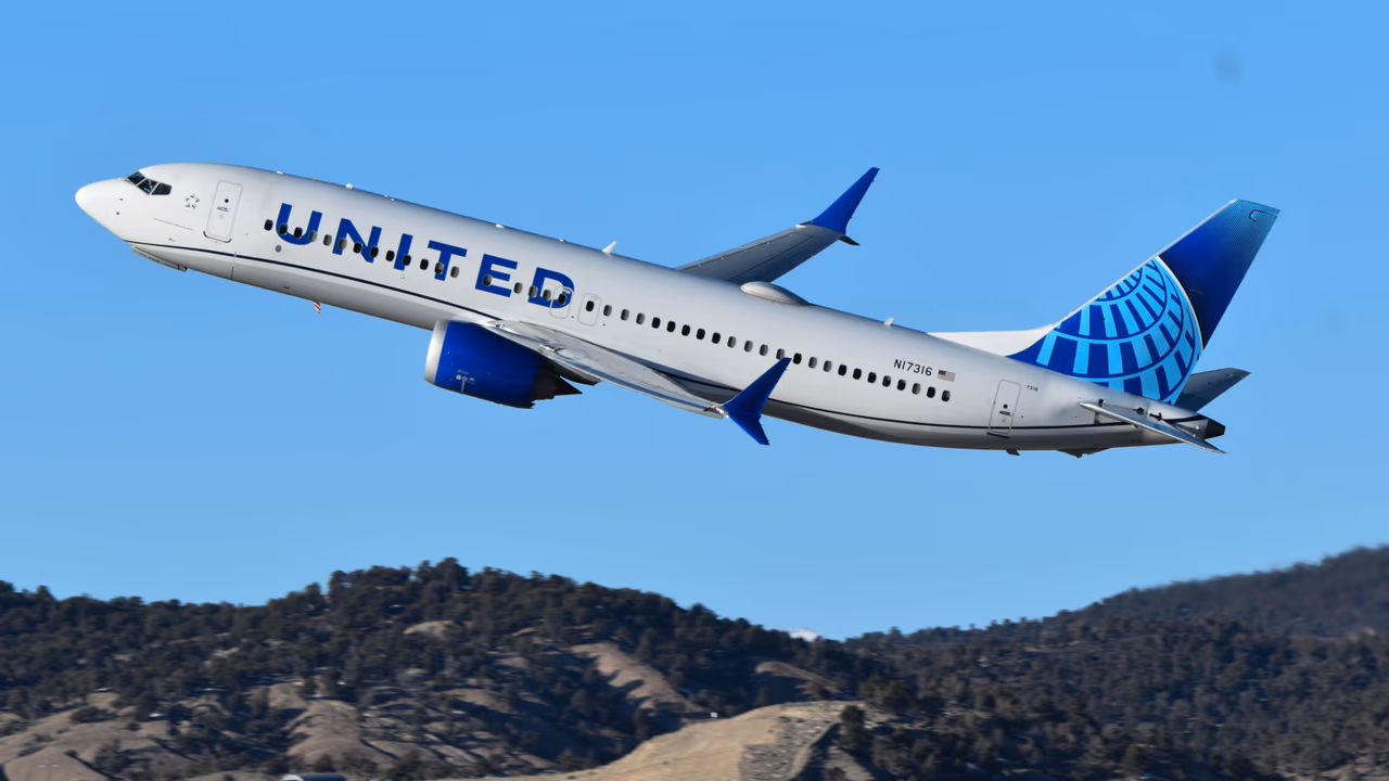 United Airlines plane taking off over hills