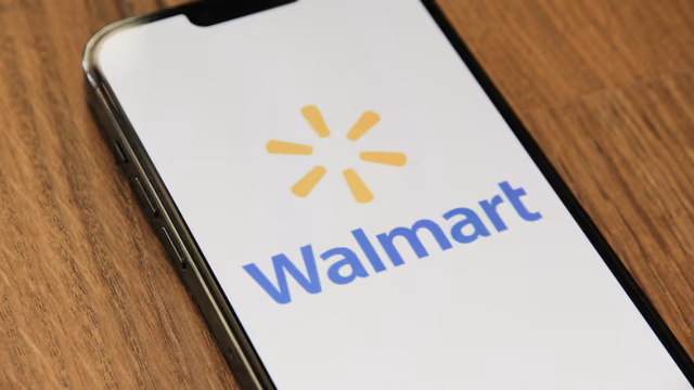 Smartphone displaying Walmart logo on screen on wooden surface