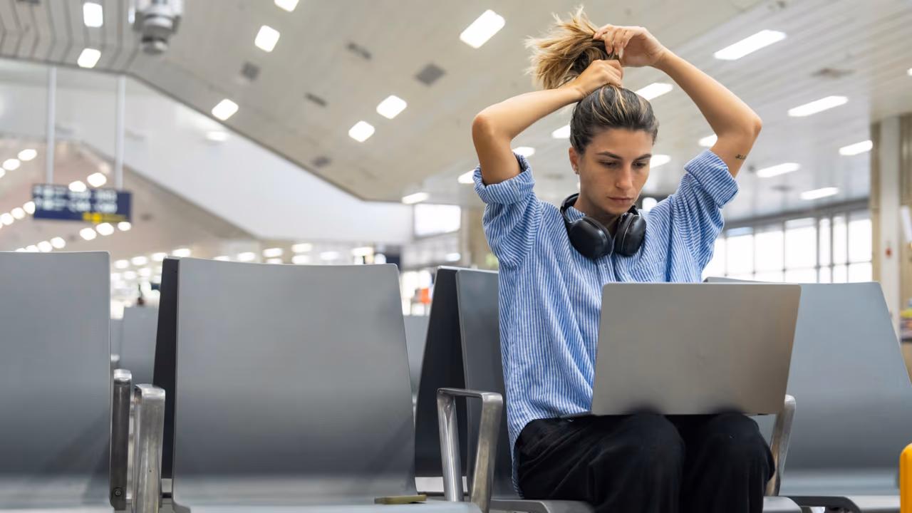 Traveler working on laptop at airport gate