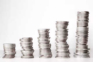 Stacks of coins of varying heights on a flat surface