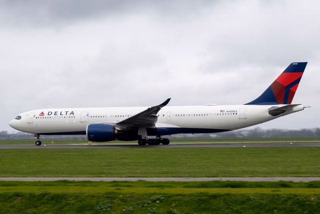 A Delta Air Lines Airbus A330 in the airline's livery taxiing along a runway under a cloudy sky