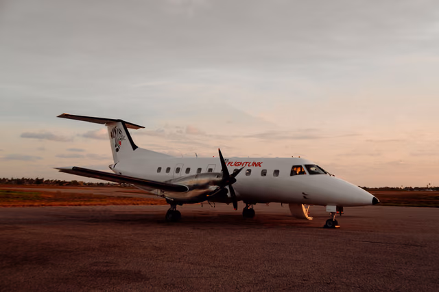 Regional airliner parked on an airport apron at sunrise