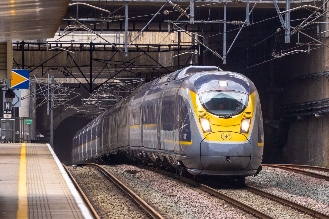 A Eurostar high-speed train leaving a tunnel and arriving at a platform