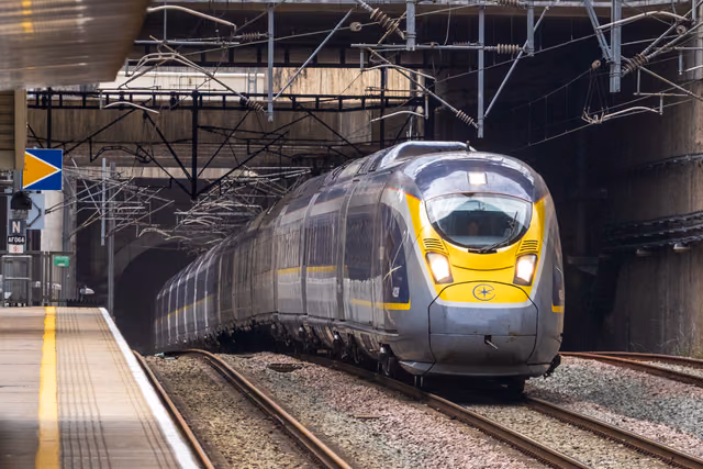 A Eurostar high-speed train leaving a tunnel and arriving at a platform