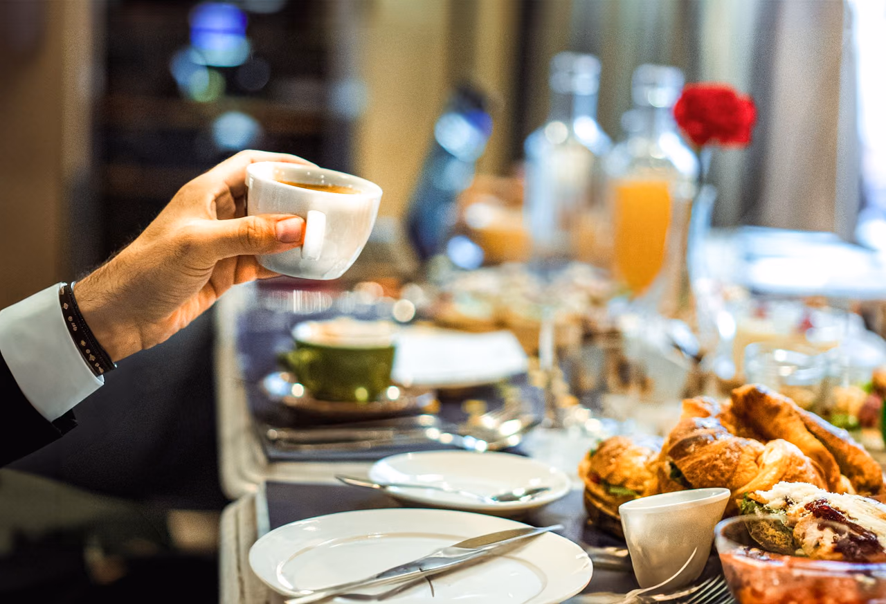 Hotel breakfast table with coffee, croissants and orange juice