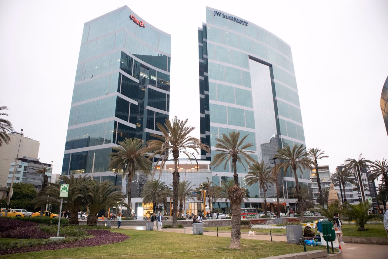 JW Marriott hotel in Lima, a modern glass-fronted tower with palm trees in the foreground