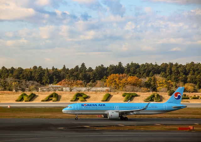A Korean Air passenger jet taxiing on a runway at Narita Airport under a cloudy sky