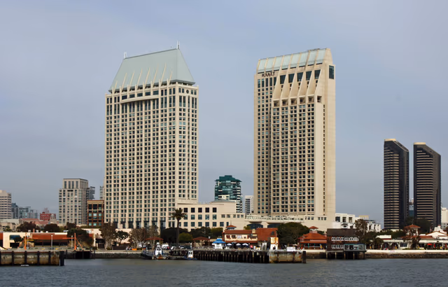 Two Hyatt hotel towers rising above the San Diego waterfront, seen across the harbor on a clear day