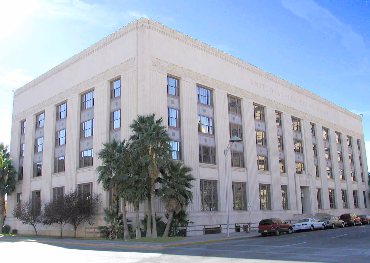 The stone facade of the United States Court House in El Paso, Texas, with palm trees in front