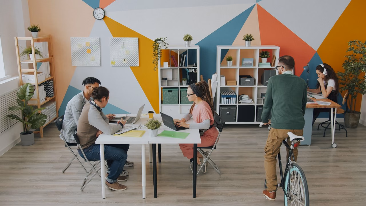A small team working together at tables in a bright modern coworking space
