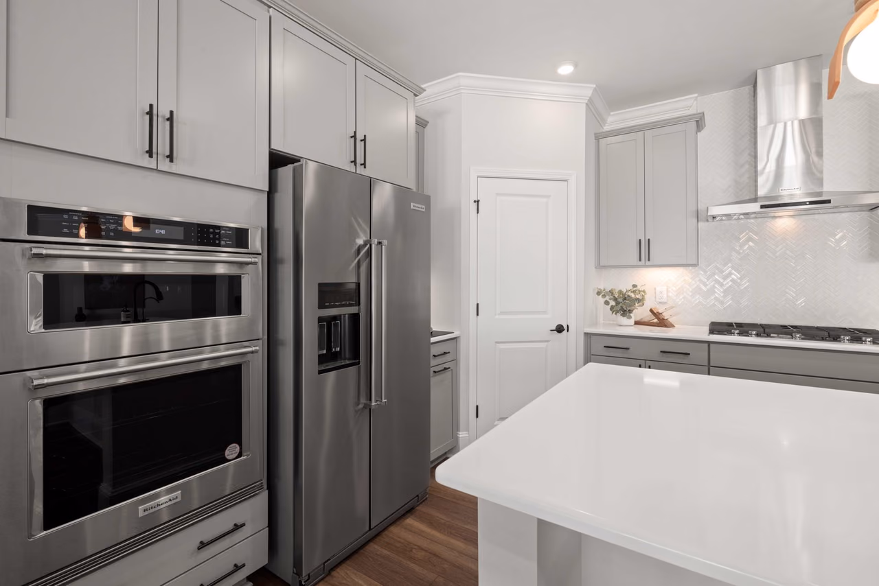 A contemporary kitchen with stainless steel appliances and minimalist cabinets