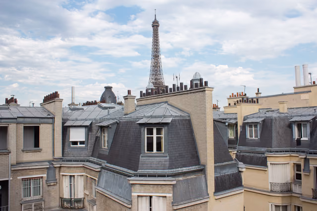 Parisian rooftops with the Eiffel Tower in the distance on a clear day