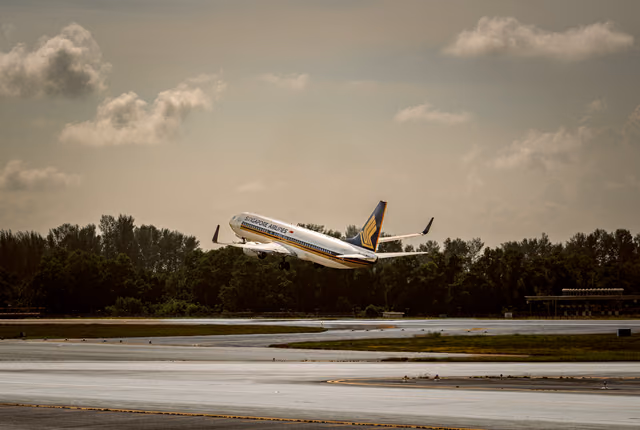 A passenger jet lifting off a runway into a partly cloudy sky