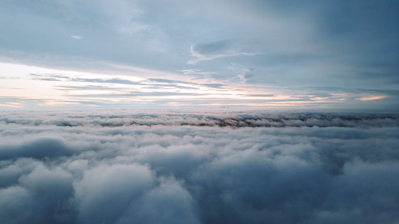 Fluffy clouds under a soft pastel sky at dawn