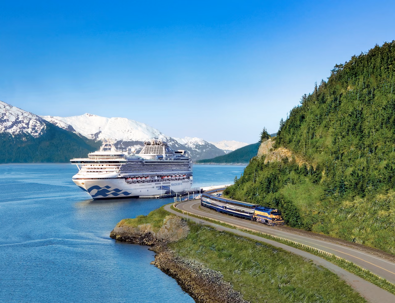 A Princess cruise ship docked beside a blue and yellow train on a shoreline track, with snow-capped mountains behind