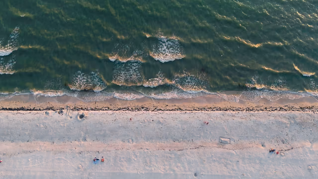 Aerial view of a Sarasota beach in Florida with sandy shores and gentle waves at sunset
