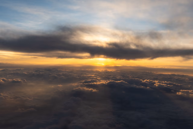 Sun rising above a layer of clouds with warm golden light