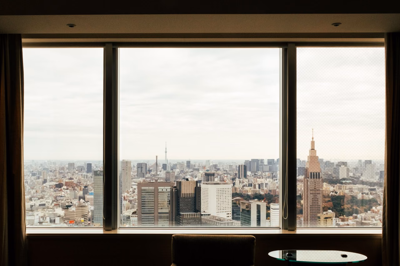 Tokyo's skyline seen from a high-floor hotel window, with Tokyo Skytree rising in the distance under an overcast sky
