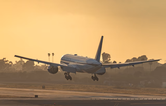 United Airlines jet landing on a runway at sunset