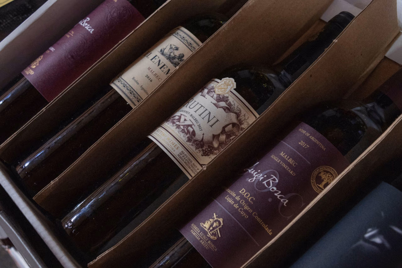 Bottles of red wine lying in a cardboard case, each in its own slot between cardboard dividers